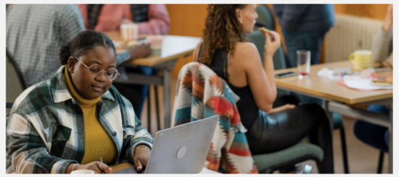 Screenshot of a banner secondary in use on a Drupal website. Image shows a lady with a laptop at a desk in a cafe.
